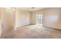 Spacious living room with neutral carpet, light walls, and a sliding door to the balcony at 5950 Barbosa Dr # 8, North Las Vegas, NV 89031