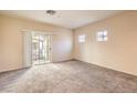 Bright living room featuring neutral carpet, light walls, and a sliding door to the balcony at 5950 Barbosa Dr # 8, North Las Vegas, NV 89031