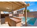 Backyard featuring a covered bar area overlooking the sparkling pool and private block wall fence at 6019 Sonoma Station Ave, Las Vegas, NV 89139