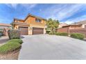Home with a three-car garage, an extended driveway, and lush landscaping adding to the overall charm at 6659 Alder Flower Ct, North Las Vegas, NV 89084