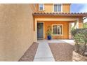 Charming front porch with a dark blue door, decorative wreath, potted plants, and patio furniture at 6659 Alder Flower Ct, North Las Vegas, NV 89084