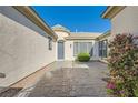 Private courtyard featuring a stone-paved patio, lush landscaping, and a charming entry door at 8305 Chapelle Ct, Las Vegas, NV 89131