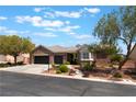 Charming brick home featuring a three-car garage, landscaped front yard, and a beautiful bay window at 8504 Mystic Night Ave, Las Vegas, NV 89143
