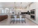 Bright kitchen featuring white cabinets, a center island with seating, stainless steel appliances, and modern pendant lighting at 8504 Mystic Night Ave, Las Vegas, NV 89143