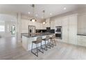 Bright kitchen featuring white cabinets, a center island with seating, stainless steel appliances, and modern pendant lighting at 8504 Mystic Night Ave, Las Vegas, NV 89143