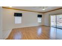 Living room with wood-look floors, ceiling fan, and two windows with roller shades at 1793 Eagle Village Ave, Henderson, NV 89012