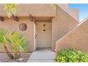 Condo entrance featuring a light-colored door and desert landscaping at 2964 Juniper Hills Blvd # 104, Las Vegas, NV 89142