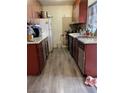 Traditional kitchen with wood cabinets, appliances, and laminate flooring at 4017 Edgeford Pl, Las Vegas, NV 89102