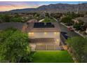 An elevated view of the backyard, mountains, surrounding neighborhood, and rooftop solar panels at 4905 Apache Valley Ave, Las Vegas, NV 89131