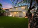 Expansive backyard featuring artificial turf, a covered patio, and partial desert views at 4905 Apache Valley Ave, Las Vegas, NV 89131