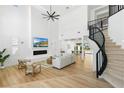 Bright, open living room features high ceilings, a modern fireplace, and beautiful staircase at 5225 Villa Dante Ave, Las Vegas, NV 89141