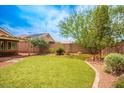 Well-maintained backyard with lush lawn, mature trees, and partial shade offers outdoor enjoyment at 8340 Jeremiahs Lodge Ave, Las Vegas, NV 89131