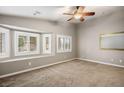 Bright bedroom with neutral walls, plush carpet, ceiling fan, and windows with shutter-style blinds at 8340 Jeremiahs Lodge Ave, Las Vegas, NV 89131