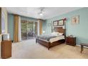 Relaxing bedroom boasts a ceiling fan, decorative furniture, and a sliding glass door leading to the backyard at 9900 Summer Ash Ct # 101, Las Vegas, NV 89134
