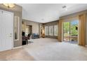 Bright and airy living room with a fireplace, sliding glass door, and neutral carpeting at 9900 Summer Ash Ct # 101, Las Vegas, NV 89134