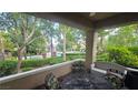 Relaxing covered patio with comfortable seating, offering a serene outdoor space with views of the pool and lush landscaping at 9900 Summer Ash Ct # 101, Las Vegas, NV 89134