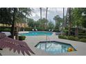 Community pool and spa surrounded by lush greenery, providing a resort-style amenity for relaxation and recreation at 9900 Summer Ash Ct # 101, Las Vegas, NV 89134