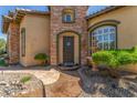 Stunning front entrance with stone accents, mature landscaping, and a decorative water feature at 9992 Peak Lookout St, Las Vegas, NV 89178