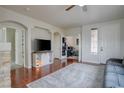 Bright living room with hardwood floors, a modern TV console, and arched doorways at 10605 Moon Flower Arbor Pl, Las Vegas, NV 89144