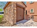 A stone detached garage with a wood garage door at 2497 Birch Hollow St, Henderson, NV 89044