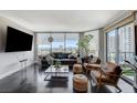 Open living room featuring hardwood floors, comfortable seating, and a large television at 322 Karen Ave # 601, Las Vegas, NV 89109