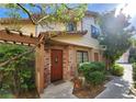 Charming townhouse entrance with a brick accent wall and a decorative wooden door at 3232 Dayflower St # 4, Las Vegas, NV 89121