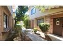 Townhouse exterior with a welcoming walkway, lush greenery, and a warm, inviting ambiance at 3232 Dayflower St # 4, Las Vegas, NV 89121