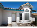 Inviting home entrance with a well-maintained stucco exterior, decorative tile roof, and desert landscaping at 3236 Manzanita Ln, Laughlin, NV 89029