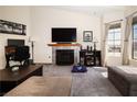 Cozy living room features a fireplace with tile surround, media center, and neutral carpeting at 3236 Manzanita Ln, Laughlin, NV 89029