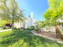 Beautiful home exterior with manicured lawn, mature trees, and bright blue skies at 451 Rumford Pl, Henderson, NV 89074