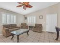 Inviting living room with large windows, tile flooring, and a decorative ceiling fan at 5109 Midnight Oil Dr, Las Vegas, NV 89122