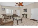 Bright living room featuring tile flooring, comfortable seating, and an eye-catching ceiling fan at 5109 Midnight Oil Dr, Las Vegas, NV 89122