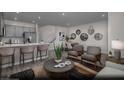 Open-concept living room featuring modern furnishings, neutral tones, and a seamless flow to the dining area at 620 Bellus Pl # Lot 168, Henderson, NV 89015