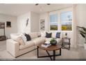 Inviting living room with a large sectional sofa, decorative rug, and abundant natural light from the expansive windows at 624 Bellus Pl # Lot 170, Henderson, NV 89015