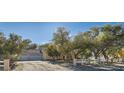 Spacious property with a three-car garage, desert landscaping, and a white fence at 6325 Guy Ave Ave, Las Vegas, NV 89131