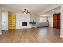 Open-concept living room featuring wood-look tile flooring, a white stone fireplace, and ample natural light at 67 Oklahoma Dr, Henderson, NV 89015