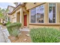 A sun-washed exterior, with manicured shrubs, leading to a warm and inviting front entrance at 6739 Twisted Wood Dr, Las Vegas, NV 89148