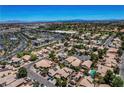 High-angle view of homes in a community near shopping centers and desert landscape under a clear sky at 7625 Raven Hills Dr, Las Vegas, NV 89149