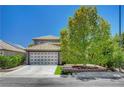 Charming home featuring a two-car garage, well-manicured lawn and desert landscaping at 7625 Raven Hills Dr, Las Vegas, NV 89149