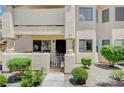 Close up of the front entrance to the condo, featuring a gated entry, security door, and well kept yard at 7952 Diamond Rock Way # 102, Las Vegas, NV 89128