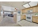 Well-lit kitchen featuring white appliances, tile floors, and a view into the living room at 8070 W Russell Rd # 1036, Las Vegas, NV 89113