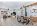 An open-concept living room with a fireplace, modern decor, and a dining area with a wine rack at 81 Alerion St, Las Vegas, NV 89138