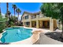 Inviting pool area featuring lush landscaping, a covered patio, and a second-story balcony at 8113 Gothic Ave, Las Vegas, NV 89117