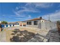 A large driveway offers ample parking space, complemented by a secure gate and partial privacy fence at 813 E Bartlett Ave, North Las Vegas, NV 89030