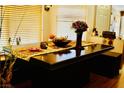 Elegant dining area featuring a wooden table with decor, complemented by natural light from the window at 9355 W Viking Rd, Las Vegas, NV 89147