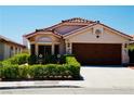 Inviting single-story home with a terracotta roof, a manicured lawn, and a convenient two-car garage at 9355 W Viking Rd, Las Vegas, NV 89147