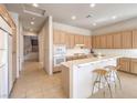 Spacious kitchen with a central island, tile flooring, neutral cabinets, and modern appliances, ready for culinary adventures at 1 Ibis Ct, Henderson, NV 89052