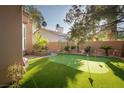 Private backyard with a putting green, mature trees, and well-maintained landscaping at 2108 Inverness Dr, Henderson, NV 89074