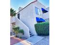 Exterior view showing the condo entrance with stairs and mature landscaping, accenting the architecture of the home at 4331 Sanderling Cir # 46, Las Vegas, NV 89103