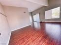 Spacious living room featuring sleek wood floors, high ceilings, and natural light from a large window and sliding glass door at 4331 Sanderling Cir # 46, Las Vegas, NV 89103